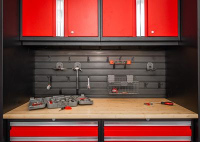 Garage with red cabinets tools on slatwall