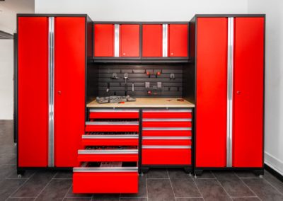 Garage with red cabinets and black flooring