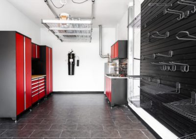 Garage with red cabinets and black flooring
