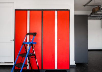 Garage with red cabinets and black flooring