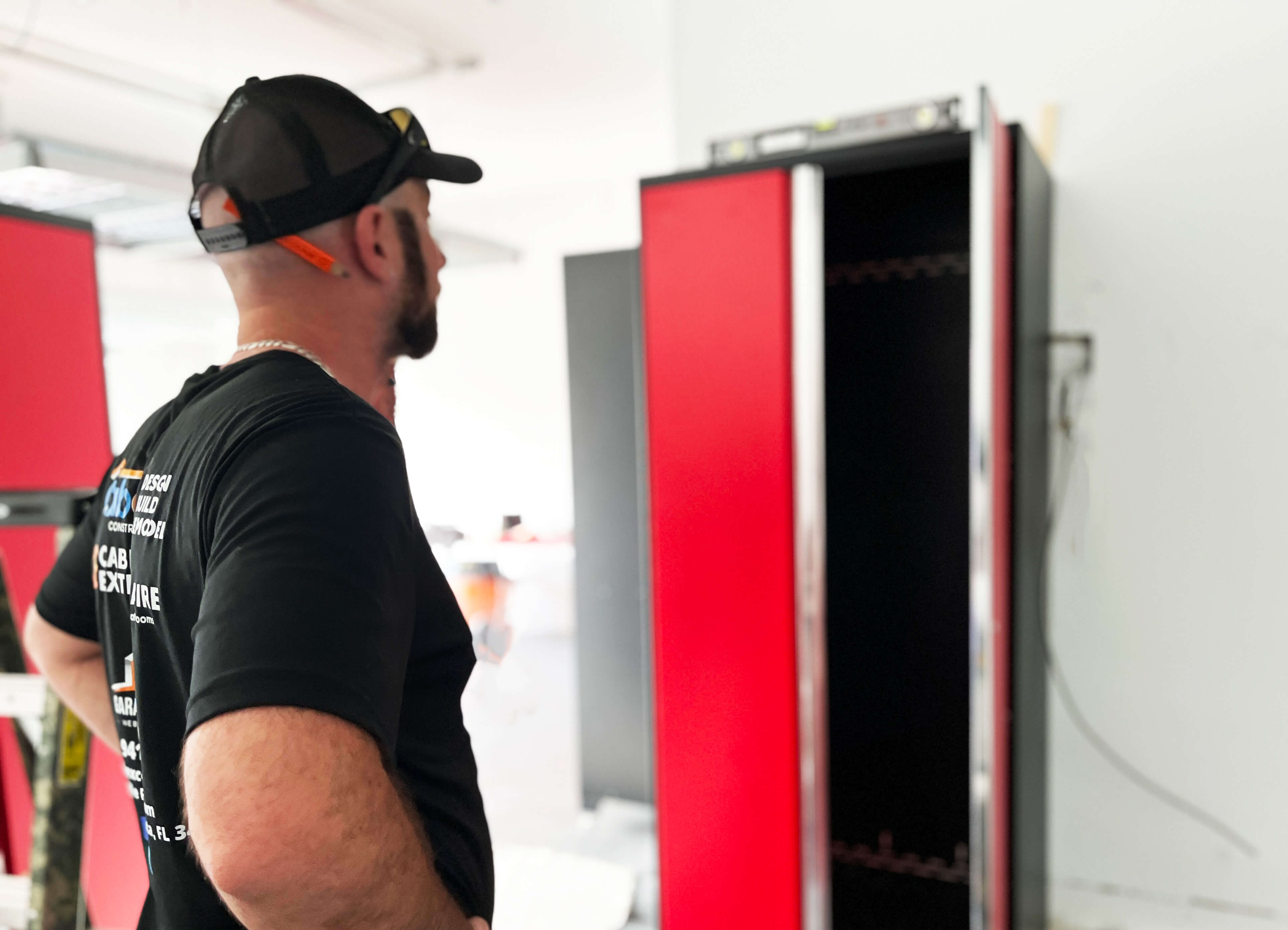 Man looking at red garage cabinets